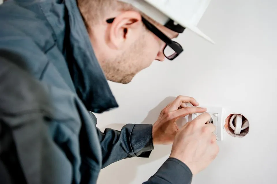 Técnico instalando un tomacorriente durante un trabajo de electricidad