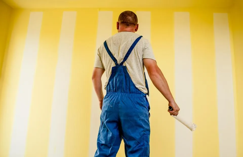 Pintor terminando una pared interior con rodillo